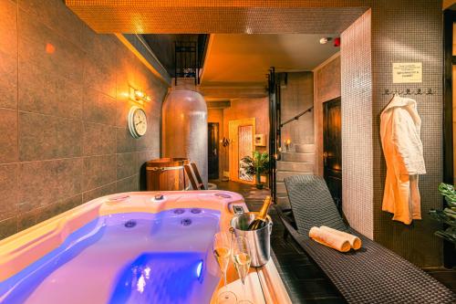 a bathroom with a large tub in a room at Komló Hotel Gyula in Gyula