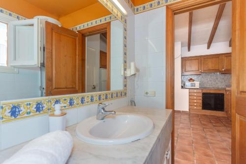a bathroom with a sink and a mirror at S'avarqueta in Son Xoriguer