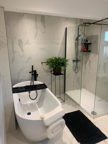 a white bathroom with a shower and a toilet at 4 bedroomed luxury house in the heart of Beatles land in Childwall