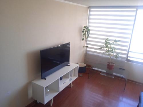 una sala de estar con TV de pantalla plana en un armario blanco en Departamento Santiago Centro, en Santiago