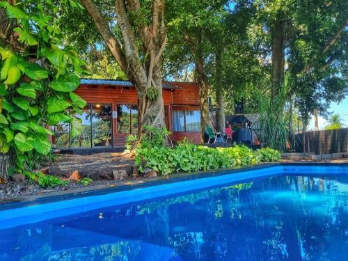 een huis met een zwembad en bomen bij La Casa Del Lago URUGUA-Í in Puerto Iguazú