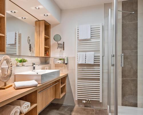 ein Bad mit einem Waschbecken und einer Dusche in der Unterkunft Hotel Astoria in Bad Füssing