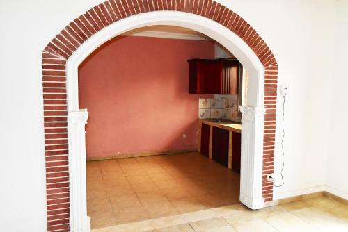 an archway in a kitchen with a red wall at Résidence Hotelière Borel Denver in Douala