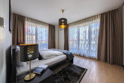 a bedroom with a bed and a table with a lamp at Alibi Apartments in Wrocław