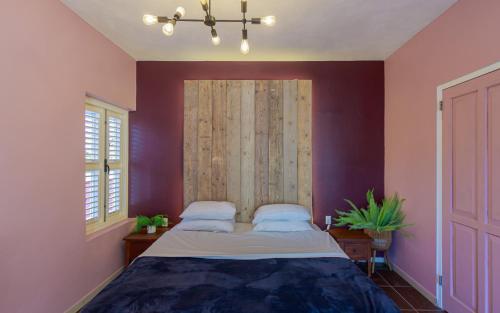 a bedroom with a large bed with purple walls at Atelier Skalo Boutique Hotel in Willemstad
