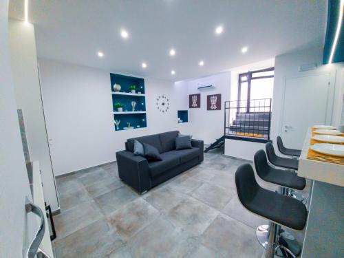 een woonkamer met een zwarte bank en stoelen bij Le Segrete del Castello, al centro Storico di Catania in Catania