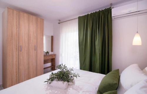 een slaapkamer met een bed met een groen gordijn bij Lena Apartments 3 in Potos
