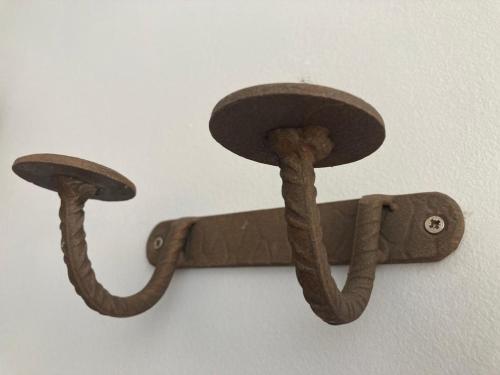 a wooden hook with two snakes hanging on a wall at Casa rural fuenteciruelos in Guzmán
