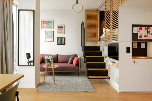 uma sala de estar com um sofá e uma mesa em Zoku Paris em Paris