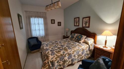 a bedroom with a bed and a lamp and a chair at Chalet La Sort in Botarell