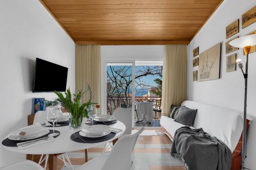 sala de estar con mesa blanca y sillas en Apartments Paunovic, en Makarska