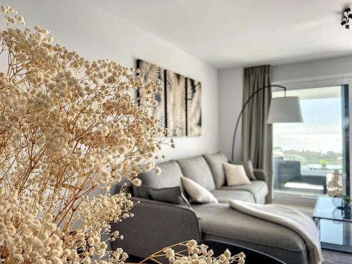 een woonkamer met een grijze bank en een groot raam bij Via Celere 2332 Luxury Sea View Apartment in Casares