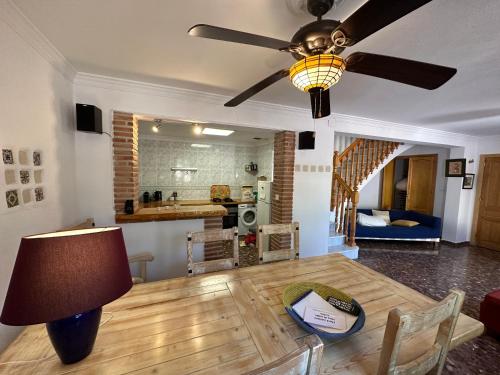 a living room with a table and a ceiling fan at Casa El Chorro con magníficas vistas in El Chorro
