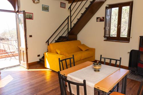 a living room with a yellow couch and a table at Case Gemmellaro - Family&Friends in Nicolosi
