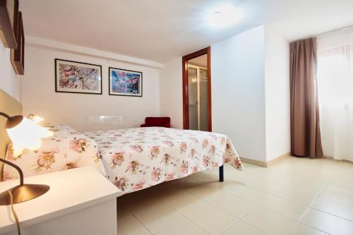 a bedroom with a bed and a table with a lamp at Case Bongiovi in Sciacca