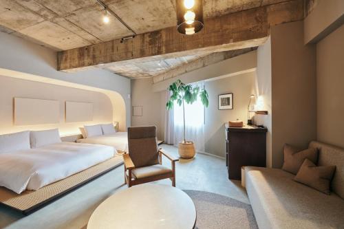 a bedroom with two beds and a table and a chair at Korinkyo in Kanazawa
