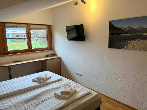 Una cama o camas en una habitación de Gästehaus Forggensee