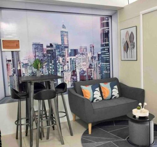 a living room with a couch and a view of a city at Chic 2BR Condo Unit at South Residences in Manila