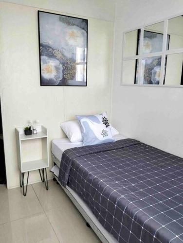 a bedroom with a bed and a side table at Chic 2BR Condo Unit at South Residences in Manila