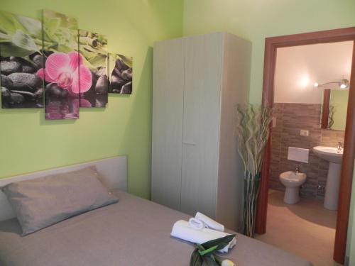 1 dormitorio con 1 cama y baño con lavamanos en Il Giardino Di Stella, en Frascati
