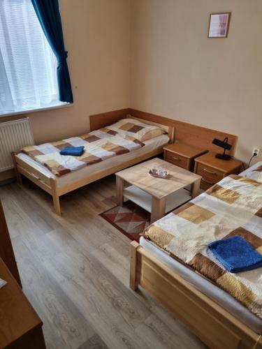 a room with two beds and a table at Penzion Arcadia in Nové Zámky