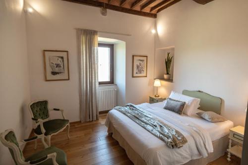 a bedroom with a bed and a chair and a window at Colle del Vento in Todi