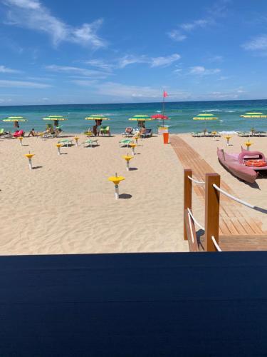 een strand met stoelen en parasols en de oceaan bij La dimora dei nonni in Tuglie