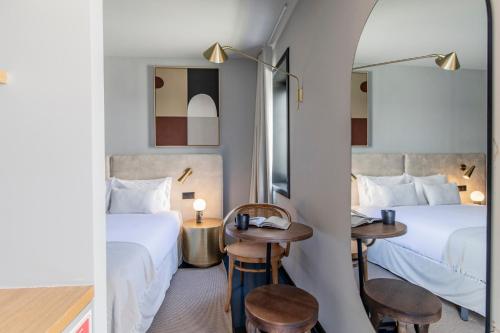 een hotelkamer met 2 bedden en een spiegel bij Regras 45 Building B by LovelyStay in Porto