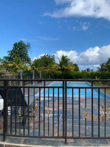 Una vista de la playa desde el balcón de un resort. en Location villa et piscine privé, en Capesterre-Belle-Eau