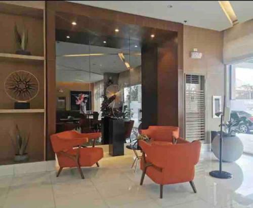 a lobby with orange chairs and a salon at Chic 2BR Condo Unit at South Residences in Manila