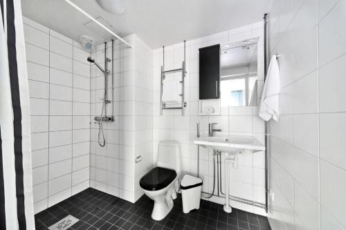 ヘルシンキにあるフォーノム サービス アパートメンツ ヘルシンキ ラピンラーデンカトゥの白いバスルーム(トイレ、シンク付)