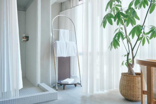 a bathroom with a mirror and a potted plant at Korinkyo in Kanazawa