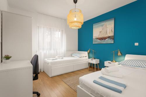 a bedroom with a white couch and a blue wall at Apartments Cesare with Shared Pool in Ližnjan