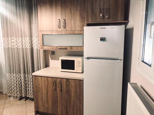 a small kitchen with a refrigerator and a microwave at Summer blossom apartment in Chalkida