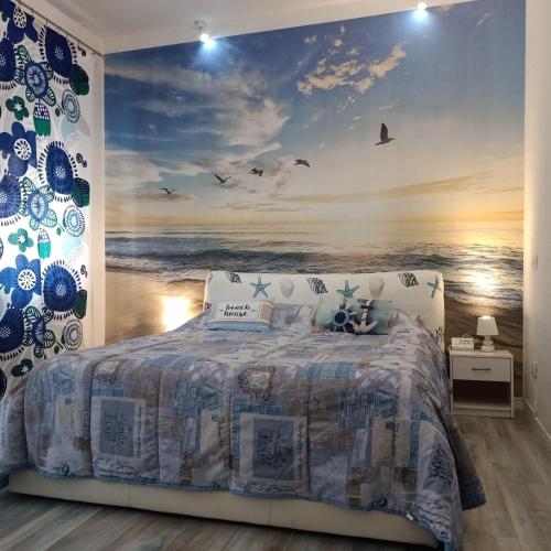 a bedroom with a large painting of the ocean at The 727 Sottomarina in Sottomarina