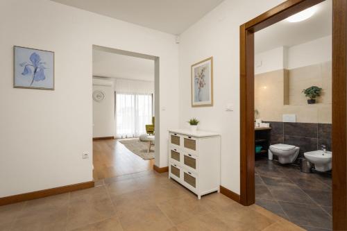 a bathroom with a sink and a toilet and a mirror at Apartments Cesare with Shared Pool in Ližnjan