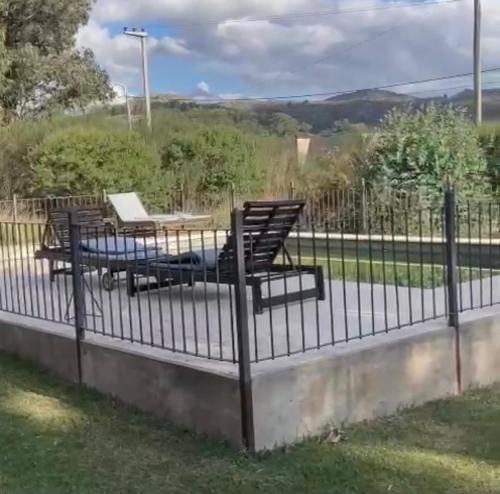 a wrought iron fence with two chairs and a table at Quinta El Monte in Tandil