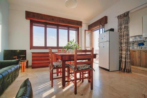 a kitchen and dining room with a table and a refrigerator at Case Bongiovi in Sciacca