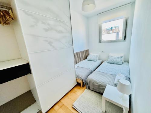 um pequeno quarto com 2 camas e um espelho em Beach & Culture Barcelona Port Forum Penthouse Apartment em Barcelona
