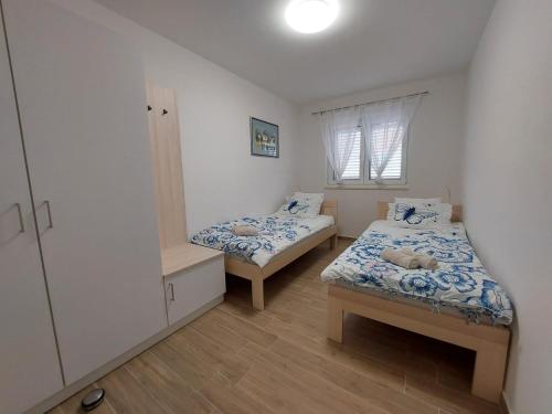 een kleine kamer met 2 bedden en een raam bij Seashells Apartments Tribunj in Tribunj