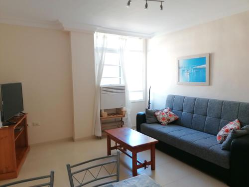 - un salon avec un canapé bleu et une table dans l'établissement Casa Ela, à Caleta de Interián