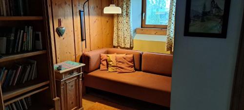 ein Sofa in einem kleinen Zimmer mit Bücherregal in der Unterkunft Haus Pierzinger in Wörgl