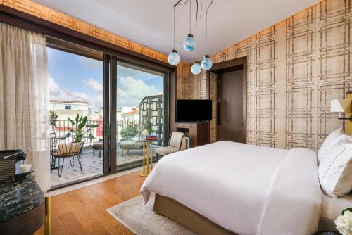 a bedroom with a large bed and a balcony at The Galata Istanbul Hotel MGallery in Istanbul