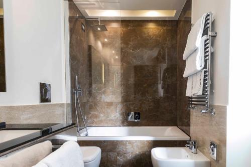 a bathroom with a tub and a toilet and a sink at Rome Times Hotel in Rome