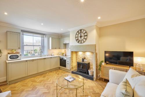 uma cozinha e sala de estar com uma mesa e uma lareira em Host & Stay - Oakwell Cottage em Birstall