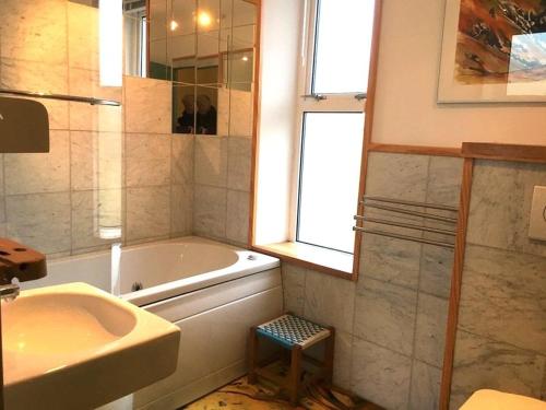 a bathroom with a tub and a sink and a window at Kilda House in Leverburgh