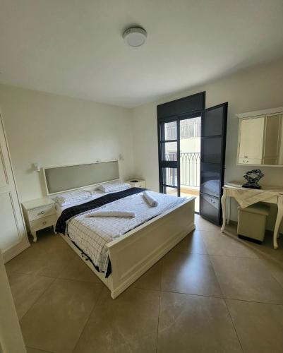 ein Schlafzimmer mit einem großen Bett und einem Balkon in der Unterkunft Luxury duplex Port of Jaffa in Tel Aviv