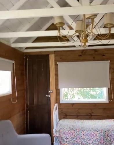a room with a bed and a window and a ceiling at Quinta El Monte in Tandil