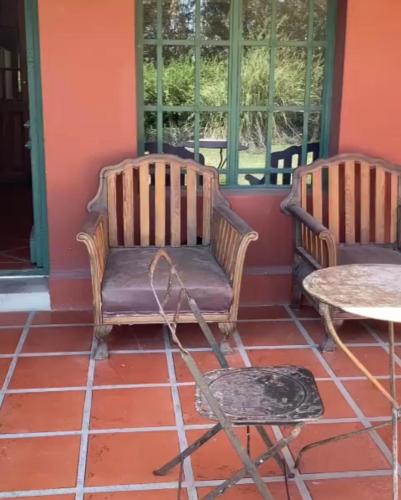 two chairs and a table on a porch at Quinta El Monte in Tandil