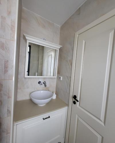 a bathroom with a white sink and a mirror at Luxury duplex Port of Jaffa in Tel Aviv